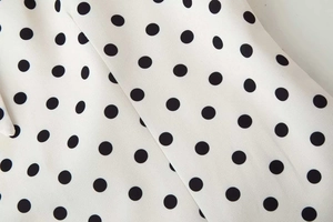 Vue macro détaillée de la texture du tissu à pois noir et blanc et de son fini imprimé