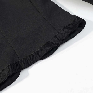 Detailed close-up of the black woven fabric jacket with ribbed elastic cuffs