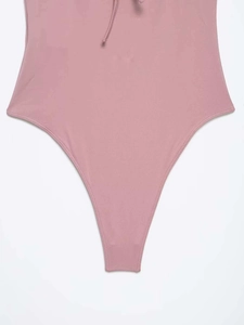 Close-up detail of dusty pink lace halter bodysuit featuring high-cut leg and fine stitching