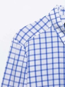 Détail d'une chemise à carreaux vichy bleu et blanc montrant la texture et les coutures
