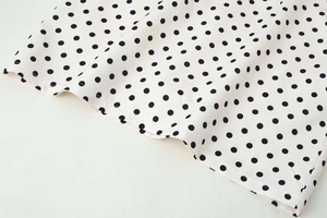 Détail de l'ourlet d'une robe d'été blanche à pois avec des finitions de couture soignées
