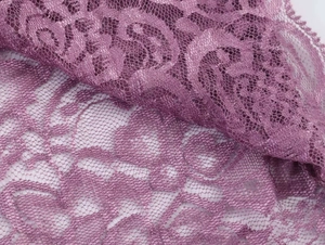Macro detail of purple floral lace fabric with intricate honeycomb mesh structure