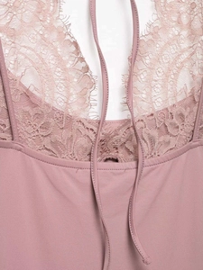 Close-up of delicate eyelash lace detailing and neck ties on the mauve bodysuit