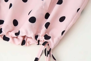 Close-up of pink polka dot jacket hem showing detailed drawstring and light chiffon fabric