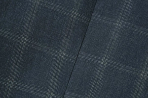 Detail shot of navy blue windowpane plaid suit fabric showing precise seam alignment
