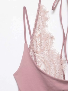 Detailed close-up of pink lace trimming and smooth fabric on a women halter bodysuit