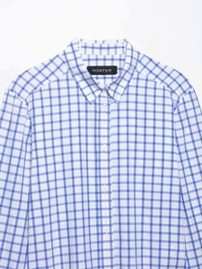 Détail d'une chemise à carreaux bleus et blancs montrant le col boutonné et l'étiquette