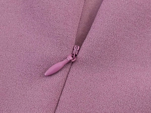 Close-up of a concealed zipper on a textured fuchsia lace dress for women