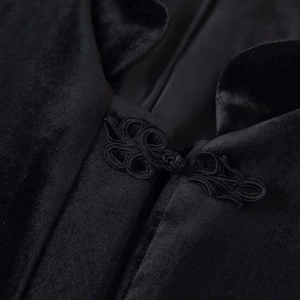Dettaglio di un blazer in velluto nero con colletto alla coreana e bottone a nodo cinese