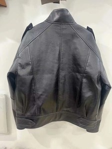 Detail view of the back of a black faux leather bomber jacket with panel stitching details