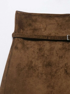 Detail of high-waist brown suede skirt with a slim matching belt and silver metal buckle