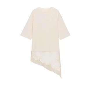 Detailed close-up of white floral lace trim on an asymmetrical apricot t-shirt hem