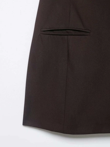 Detail view of neat stitching and invisible pocket on dark pleated twill mini dress
