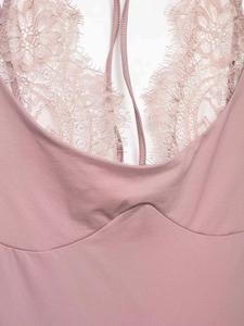 Close-up of pink lace neckline detail and fine crochet craftsmanship on a bodysuit