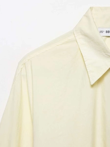 Detail of a pointed collar and stitching on a light beige cotton poplin casual shirt