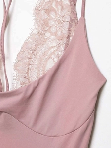 Detail of dusty rose pink lace and smooth fabric stitching on a sexy women's bodysuit