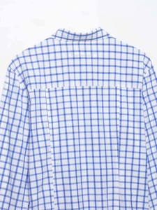 Détail du dos d'une chemise à carreaux vichy bleu et blanc avec coutures d'empiècement
