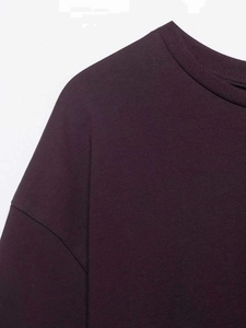 Detail shot of ribbed round neckline and shoulder seam on dark purple cotton T-shirt