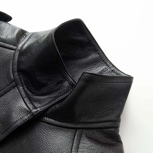 Close-up of black faux leather bomber jacket with stand collar and textured stitching