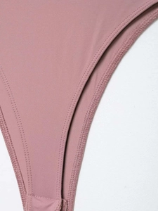 Detail of dusty pink lace bodysuit showing precision stitching and fabric texture