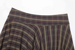 Close-up of vintage plaid skirt featuring a wide waistband and wool-like textured fabric