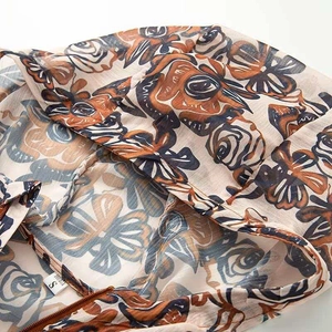 Detailed macro shot of vintage floral print chiffon fabric with brown zipper and size tag S
