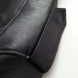 Detailed macro shot showing the fine lychee texture and stitching of black leather jacket