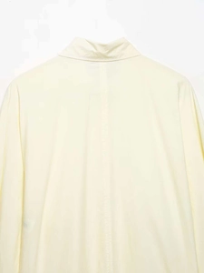 Close-up of the back neckline and central vertical seam on a cream poplin shirt