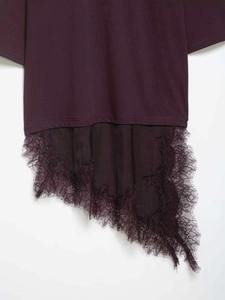 Detail of asymmetrical dark purple top with black eyelash lace trim and knit texture