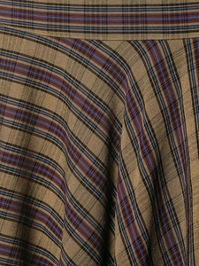 Macro detail of vintage plaid fabric showing brown, blue and red textured weave