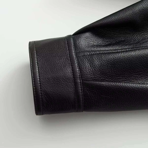 Close-up of the black faux leather texture with premium double stitching on the collar edge