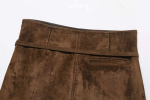 Detailed view of brown suede high waist skirt featuring belt and stitching details