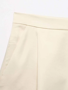 Detail view of cream tailored shorts featuring pleats and high-quality twill fabric