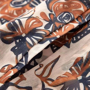 Macro shot of boho print fabric on vintage hooded jacket with vibrant orange and brown hues