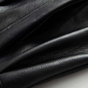 Macro detail of high-quality faux leather bomber jacket with fine stitching and litchi texture
