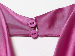 Macro view of fuchsia satin halter top collar with double button closure detail