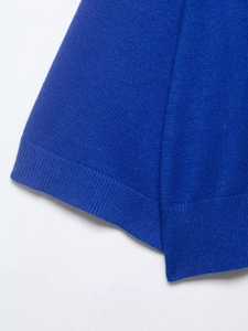 Gros plan détaillé des poignets côtelés et de l'ourlet d'un haut en tricot bleu roi
