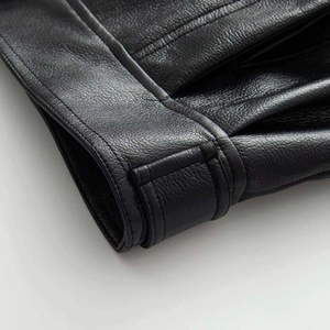 Detail of premium black faux leather bomber jacket showing double stitching and texture