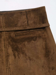 Detail macro view of brown suede skirt waist with matching belt and precise stitching