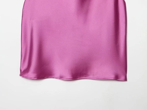 Close-up detail of magenta satin top showing smooth fabric texture and neat bottom hemline