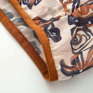 Macro detail of retro floral chiffon fabric with contrast piping and precise stitching