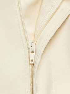 Detail of high-quality invisible zipper on smooth beige satin shorts with precise stitching