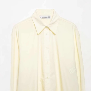 Pale yellow long sleeve poplin shirt for women featuring a classic collar and buttons