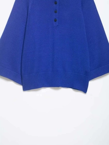 Détail d'un pull en tricot bleu roi montrant trois boutons et une texture côtelée