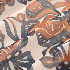 Close-up of tropical leaf print fabric with detailed weave and navy orange patterns