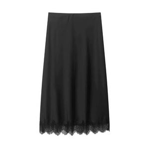 Détail d'une jupe midi en satin noir avec une bordure en dentelle délicate au bas