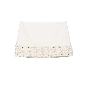 Cream pleated mini skirt with layered ruffles and metallic rivet details