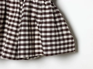 Détail du tissu à carreaux vichy marron avec texture seersucker et finitions soignées