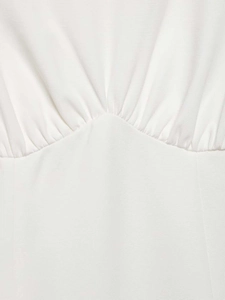 Detailed macro view of white pleated fabric with elegant waist gathering and fine texture