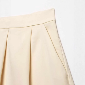 Minimalist high-waisted satin shorts with refined pleats and invisible side pockets